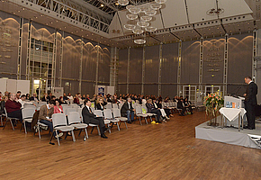 Ein Referent spricht vor einem vollen Vortragssaal am RehaKongress 2013.