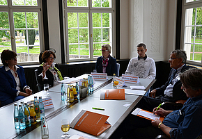 Die Geschäftsführerin der RehaZentren Baden-Württemberg sitzt mit Referentinnen und Referenten des RehaKongresses 2014 an einem Tisch.